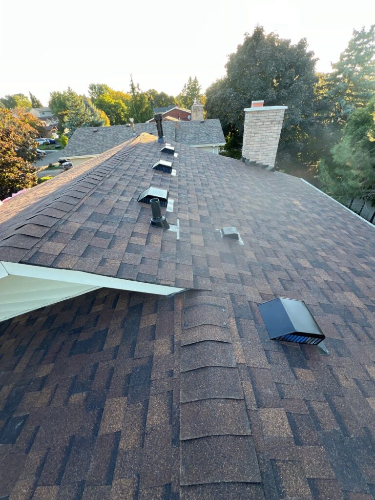 Shingle-covered roof with roof vents and chimney